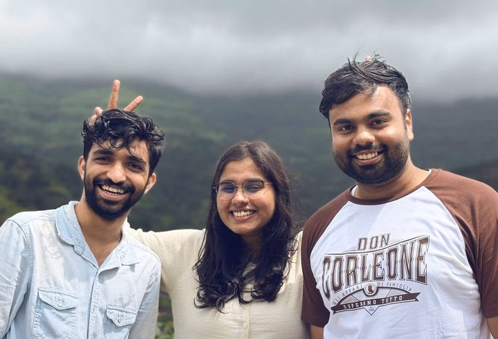 Abhinav with two friends on a cloudy hilltop, one of them making bunny ears.